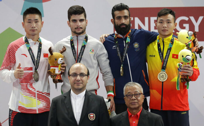 From left, silver medalist China's Xueto Wang, gold medalist Iran's Erfan Ahangarian, bronze medalist India's Surya Singh, and bronze medalist Vietnam's Truong Giang Bui during ceremonies at the wushu men's Sanda 60kg division at the 18th Asian Games on Thursday in Jakarta, Indonesia. Photo: Aaron Favila / Associated Press