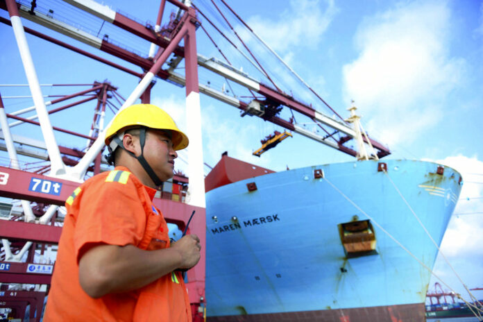 A worker stands near a container ship Aug. 8 at a port in Qingdao in eastern China's Shandong Province. Photo: Associated Press A worker stands near a container ship Aug. 8 at a port in Qingdao in eastern China's Shandong Province. Photo: Associated Press