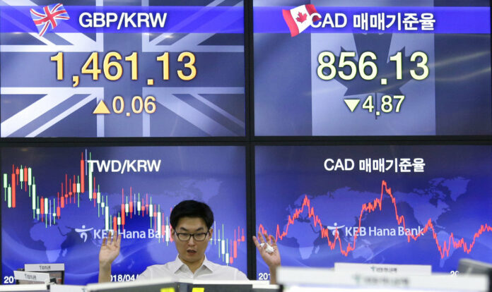 A currency trader gestures at the foreign exchange dealing room of the KEB Hana Bank headquarters Friday in Seoul, South Korea. Photo: Ahn Young-joon / Associated Press