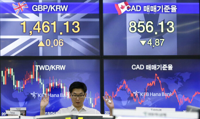 A currency trader gestures at the foreign exchange dealing room of the KEB Hana Bank headquarters Friday in Seoul, South Korea. Photo: Ahn Young-joon / Associated Press A currency trader gestures at the foreign exchange dealing room of the KEB Hana Bank headquarters Friday in Seoul, South Korea. Photo: Ahn Young-joon / Associated Press
