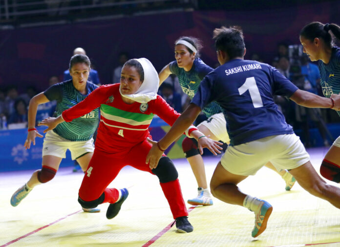 Iran's Saeideh Jafarikoochi, in red, tries to score a point as India's team defend during the women's team Kabaddi gold medal match Friday at the 18th Asian Games in Jakarta, Indonesia. Photo: Tatan Syuflana / Associated Press