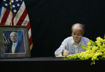 Former Vietnamese Jailer Says He Respected Late Sen. McCain Pham Minh Chuc, an 81-year-old retiree, writes a book of condolences Monday for Senator John McCain in Hanoi, Vietnam. Photo: Tran Van Minh / Associated Press