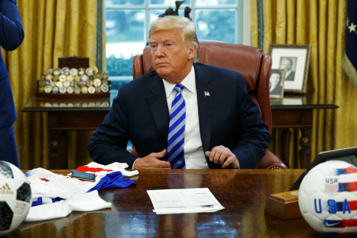 President Donald Trump listens to a question Tuesday during a meeting with FIFA president Gianni Infantino and United States Soccer Federation president Carlos Cordeiro in the Oval Office of the White House. Photo: Evan Vucci / Associated Press