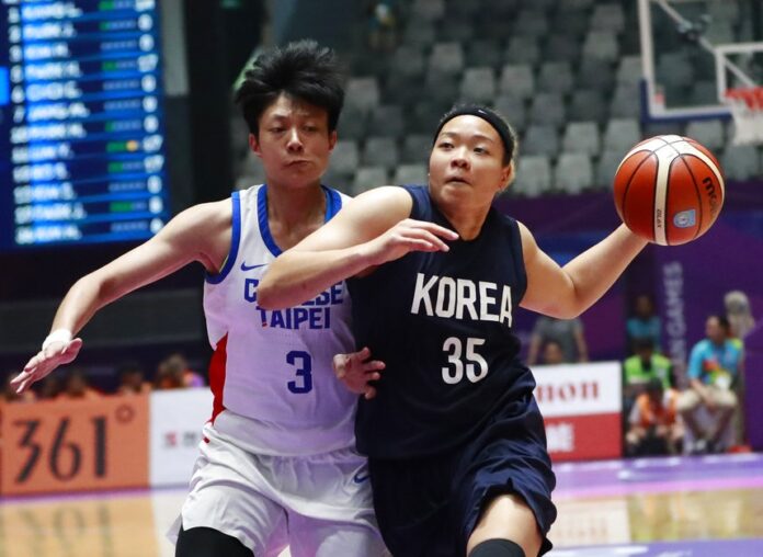 Combined Koreas' Kim Hanbyul, right, drives past Taiwan's Chen Yuchun during their women's basketball semifinal match Thursday at Istora Stadium in Jakarta, Indonesia. Photo: Dita Alangkara / Associated Press