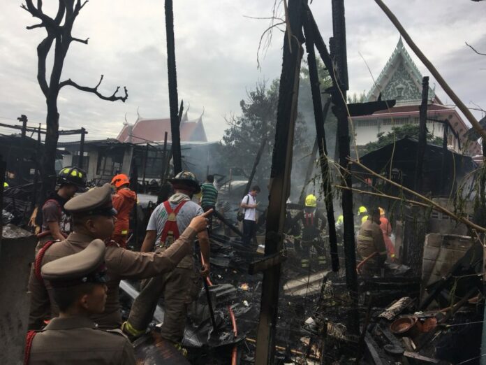Police and firemen inspect the scene of a fire Friday morning that destroyed 16 homes in Bangkok's western district of Bangkok Yai. Police and firemen inspect the scene of a fire Friday morning that destroyed 16 homes in Bangkok's western district of Bangkok Yai.