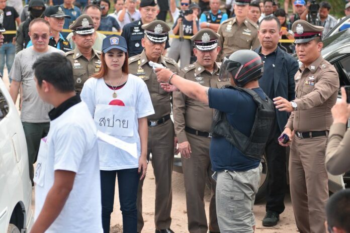 Panya ‘Siya Ouan’ Yingdang participates in a police ‘re-enactment’ Wednesday of the double murder in front of the Buddha Mountain in Chonburi province.