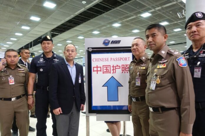 Police pose with a sign for the Chinese tourists fast-track lane on Aug. 3 at Suvarnabhumi Airport.