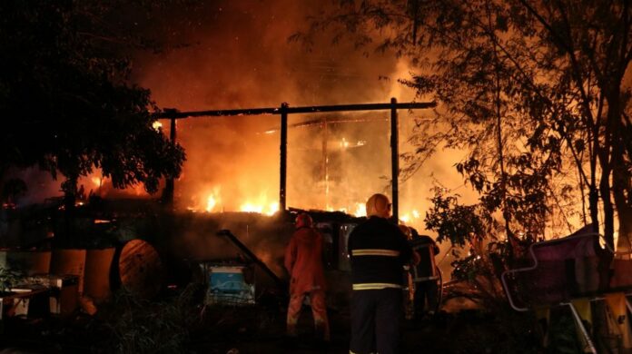 Firefighters at the scene of fire Monday morning in Bangkok’s Bang Kapi district.