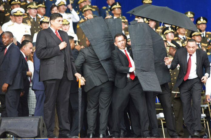 Security personnel surround Venezuela's President Nicolas Maduro during an incident as he was giving a speech Saturday in Caracas. Photo: Xinhua via AP Security personnel surround Venezuela's President Nicolas Maduro during an incident as he was giving a speech Saturday in Caracas. Photo: Xinhua via AP