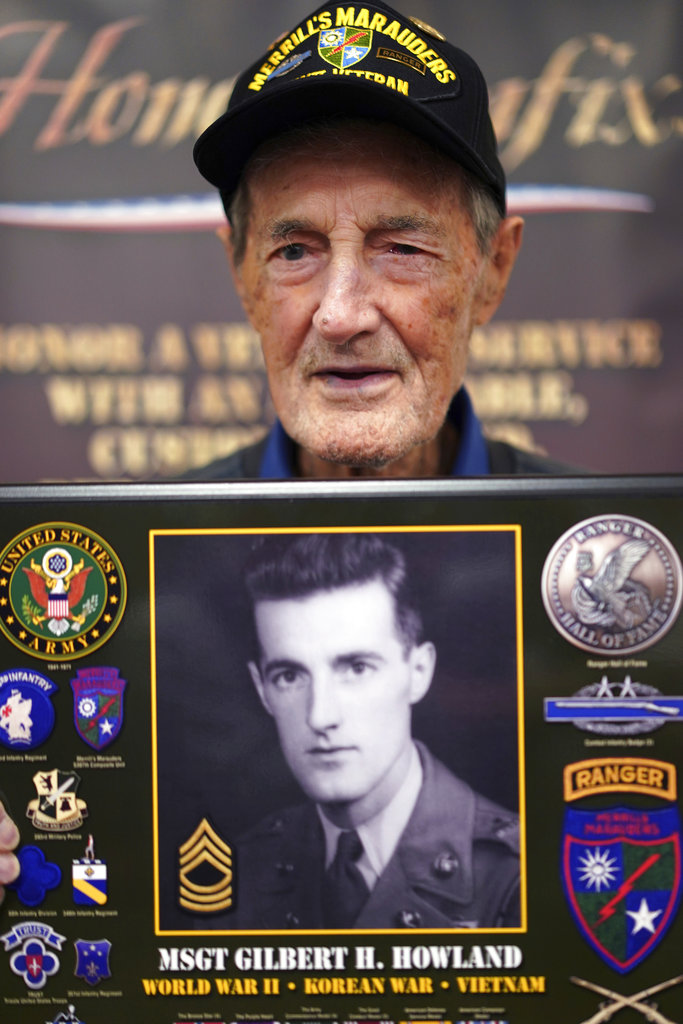 Gilbert Howland, of Langhorn, Pennsylvania, one of the few remaining members of the famed WWII Army unit Merrill's Marauders, poses for a portrait with a plaque bearing a photo of his younger self, during a gathering of remaining members, family and history buffs, in New Orleans on Tuesday. Photo: Gerald Herbert / Associated Press