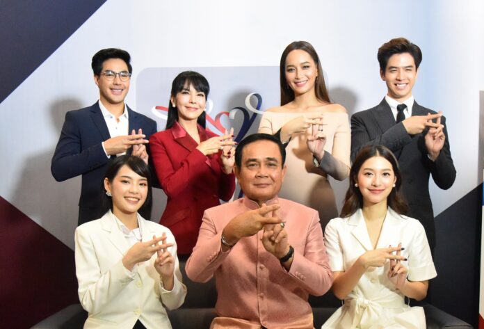 Celebs sit for a photo op with junta leader and Prime Minister Gen. Prayuth Chan-ocha to promote one of his government television programs. From back left, they are Jaron 'Top' Sorat, Mayura 'Tuk' Sawetsila, Namthip 'Bee' Jongrachatawiboo, Thanaphad 'Film' Kawila. At front from the left are Cherprang Areekul, Prayuth and Nittha 'Mew' Jirayungyurn.