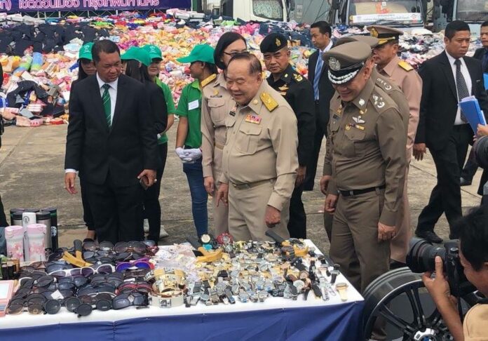 Gen. Prawit Wongsuwan on Sep. 3 checks out counterfeit brandname watches confiscated by police in Bangkok.