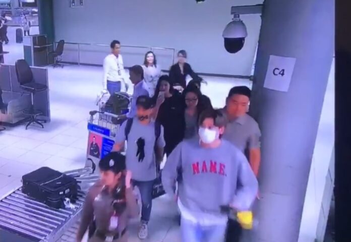 Two women who borrowed identification and uniforms to sneak into secure airport areas can be seen at the back of a crowd trailing Korean actor Lee Jong-suk on Sept. 14 at Suvarnabhumi Airport.