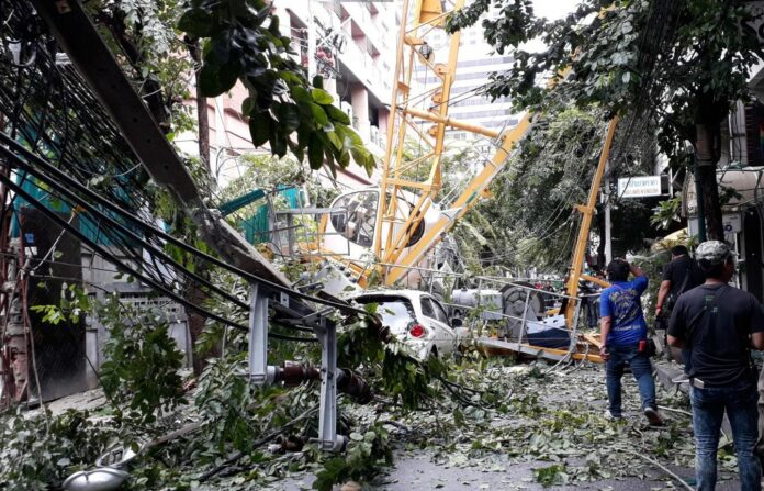 A crane collapsed on a car, trees and electric poles Friday morning in Saladaeng Road. A crane collapsed on a car, trees and electric poles Friday morning in Saladaeng Road.