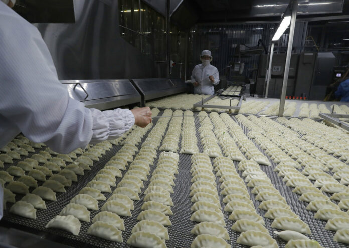 Workers inspect dumplings on a conveyor belt that are made at an automated factory of CJ CheilJedang Corp. in July in Incheon, South Korea. Photo: Lee Jin-man / Associated Press
