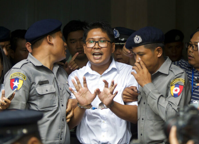 Reuters journalist Wa Lone, center, talks to journalists as he is escorted by police to leave a court in Yangon, Myanmar Monday, Sept. 3, 2018. Photo: Thein Zaw / Associated Press
