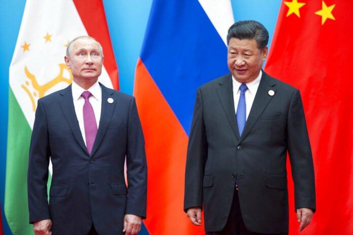 In this Sunday, June 10, 2018 file photo, Chinese President Xi Jinping, right, and Russian President Vladimir Putin pose for a photo at the Shanghai Cooperation Organization (SCO) Summit in Qingdao in eastern China's Shandong Province. Photo: Alexander Zemlianichenko / Associated Press