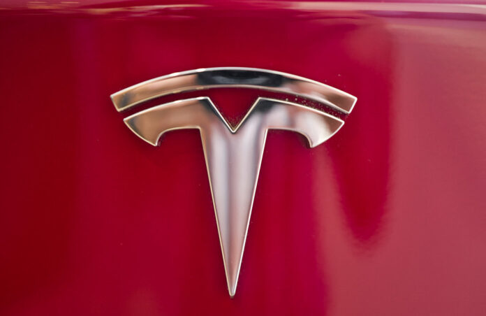 This Aug. 8, 2018, file photo shows a Tesla emblem on the back end of a Model S in the Tesla showroom in Santa Monica, California. Photo: Richard Vogel / Associated Press