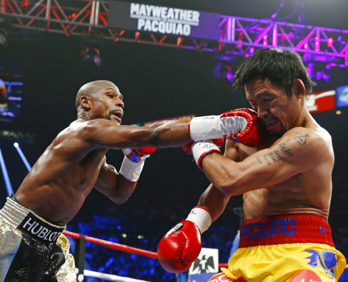 Floyd Mayweather Jr., left, connects with a right to the head of Manny Pacquiao, from the Philippines, during their welterweight title fight in 2015 in Las Vegas, Nevada. Photo: John Locher / Associated Press
