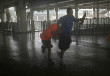 Mangkhut Lashes South China After Killing 28 in Philippines A man and a girl walk against strong winds from Typhoon Mangkhut on a pier on Victoria Habour Hong Kong, Sunday, Sept. 16, 2018. Photo: Vincent Yu / Associated Press