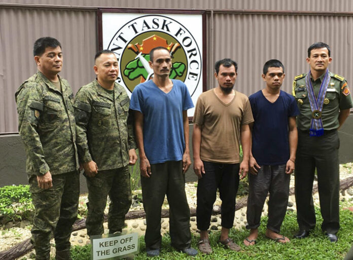 In this photo released by the Armed Forces of the Philippines, three Indonesian hostages (in civilian clothes) pose with Philippine military officers and an Indonesian military attache in Zamboanga city following their Friday release from captivity in Jolo, Sulu by Muslim militant kidnappers Sunday, Sept. 16, 2018, in the southern Philippines. Photo: Associated Press