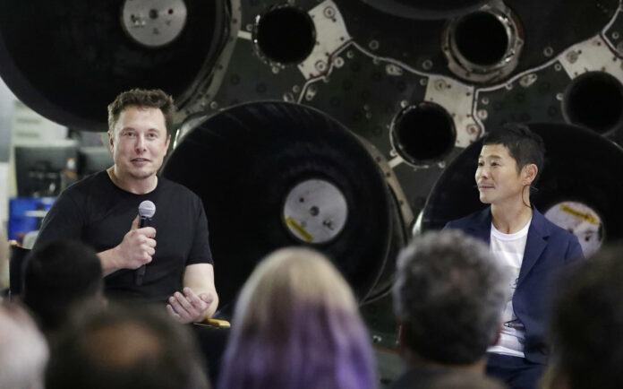 SpaceX founder and chief executive Elon Musk, left, announces Japanese billionaire Yusaku Maezawa, right, as the first private passenger on a trip around the moon, Monday, Sept. 17, 2018, in Hawthorne, California. Photo: Chris Carlson / Associated Press