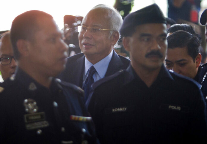 Malaysia's former Prime Minister Najib Razak, center, walks Thursday in Kuala Lumpur High Court in Kuala Lumpur, Malaysia. Photo: Yam G-Jun / Associated Press