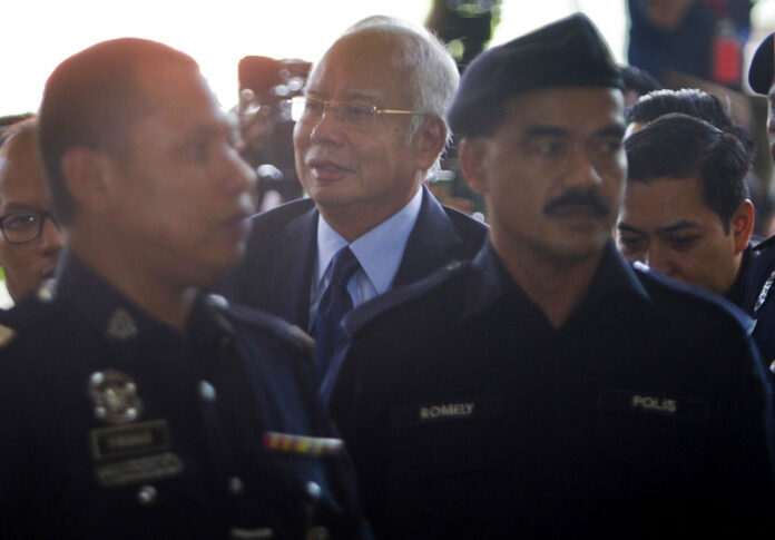 Malaysia's former Prime Minister Najib Razak, center, walks Thursday in Kuala Lumpur High Court in Kuala Lumpur, Malaysia. Photo: Yam G-Jun / Associated Press Malaysia's former Prime Minister Najib Razak, center, walks Thursday in Kuala Lumpur High Court in Kuala Lumpur, Malaysia. Photo: Yam G-Jun / Associated Press