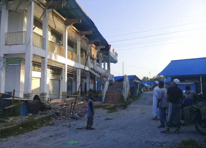 People survey a building partially damaged by earthquake in Poso, Central Sulawesi, Indonesia, Saturdayใ Photo: Yoanes Litha / Associated Press
