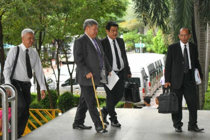 Premchai Karnasuta, a walking cane in hand, arrives at a court on Aug. 6.