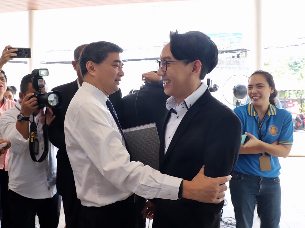 Democrat Party chairman Abhisit Vejjajiva hugs Surabot Leekpai, son of former Democrat leader Chuan Leekpai.