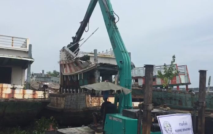 Old fishing boats are being destroyed Wednesday in Samut Sakhon province.