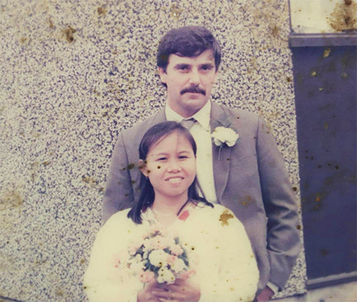 A wedding photo of Alan Hogg and Nhot Suddaen.