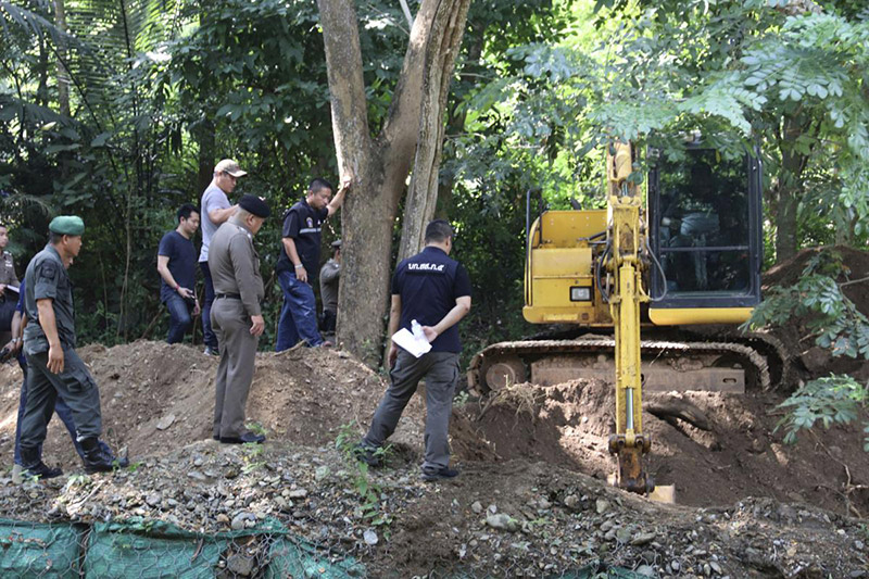 Thai officers stand by the area where the bodies of a murdered Briton and his Thai wife were found Tuesday in Phrae province. Photo: Daily News / Associated Press