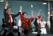 Asian Games Stir Indonesian Pride, Boost Jokowi’s Campaign Indonesian President Joko Widodo, left, and his wife Iriana wave during the Aug. 18 opening ceremony for the 18th Asian Games in the Gelora Bung Karno Stadium in Jakarta. Photo: Dita Alangakara / Associated Press