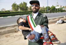 Iran Summons Western Diplomats Over Deadly Parade Attack In this photo provided by the Iranian Students' News Agency, ISNA, a Revolutionary Guard member carries a wounded boy after a shooting during a military parade marking the 38th anniversary of Iraq's 1980 invasion of Iran, in the southwestern city of Ahvaz, Iran, Saturday, Sept. 22, 2018. Gunmen attacked the military parade, killing at least eight members of the elite Revolutionary Guard and wounding 20 others, state media said. Photo: Behrad Ghasemi / ISNA via AP
