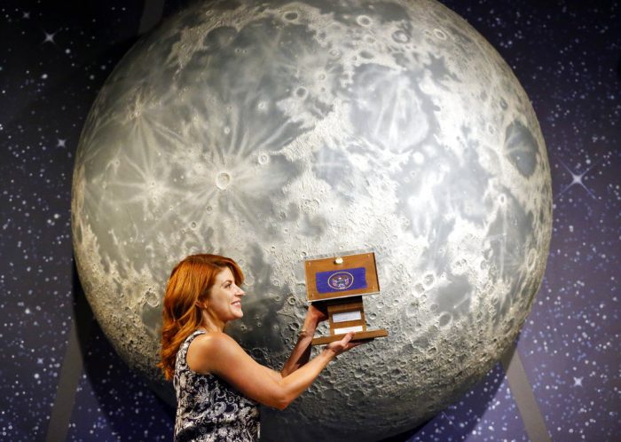 Lindsie Smith, from the Clark Planetarium, holds moon rocks encased in acrylic and mounted on a wooden plaque Aug. 23. Photo: Rick Bowmer / Associated Press