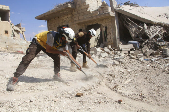 The Syrian Civil Defense group known as the White Helmets shows civil defense workers clean rubble from a house which was damaged by a Syrian government airstrike, in Hobeit village, near Idlib, Syria. Photo: Syrian Civil Defense White Helmets / Associated Press