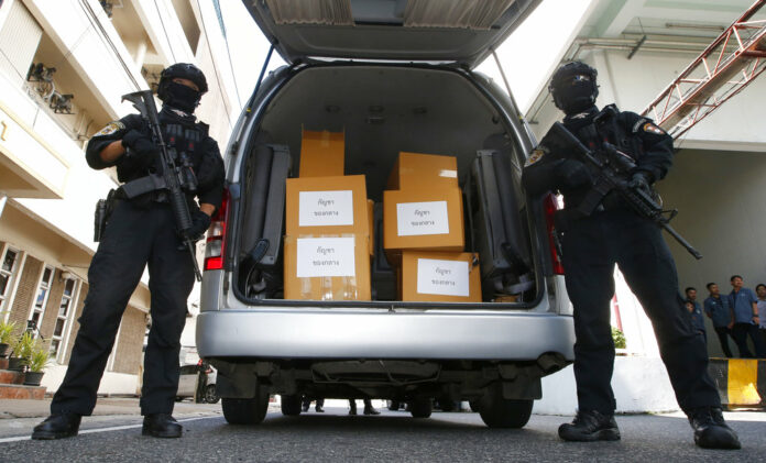 Thai policemen stand guard next to 100 kilograms of seized marijuana before a Tuesday news conference in Bangkok. Photo: Sakchai Lalit / Associated Press