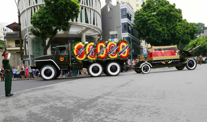 An army officer salutes as a flag-draped coffin of late President Tran Dai Quang passes on a truck-drawn artillery carriage Thursday in Hanoi. Photo: Tran Van Minh / Associated Press