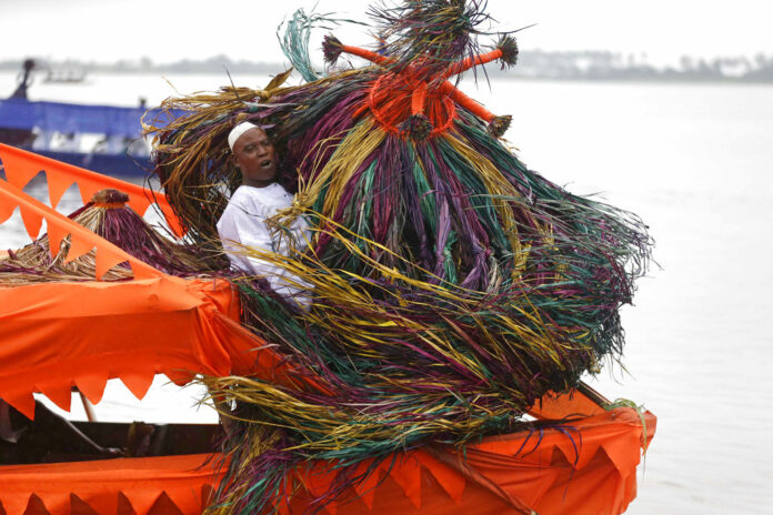 People dressed in Zangbeto masquerade costume prepare to parade during a regatta to mark the Badagry festival Saturday in Badagry, Nigeria. Photo: Sunday Alamba / Associated Press