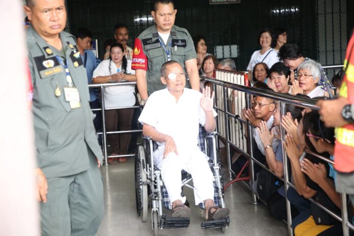 Suwit Thongprasert waves to his supporters Wednesday at the court.