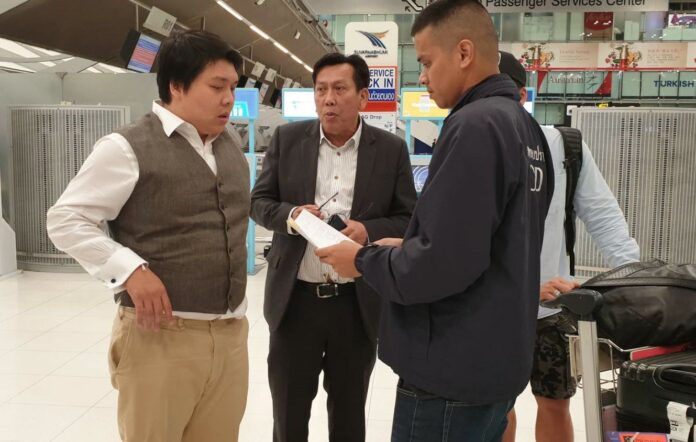 Parinya Jaravijit, left, talks to authorities Friday at Suvarnabhumi airport.