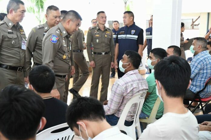 Maj. Gen. Surachet Hakpan, third from left, talks to foreigners arrested for illegally working in Thailand on Thursday at the Immigration Bureau.