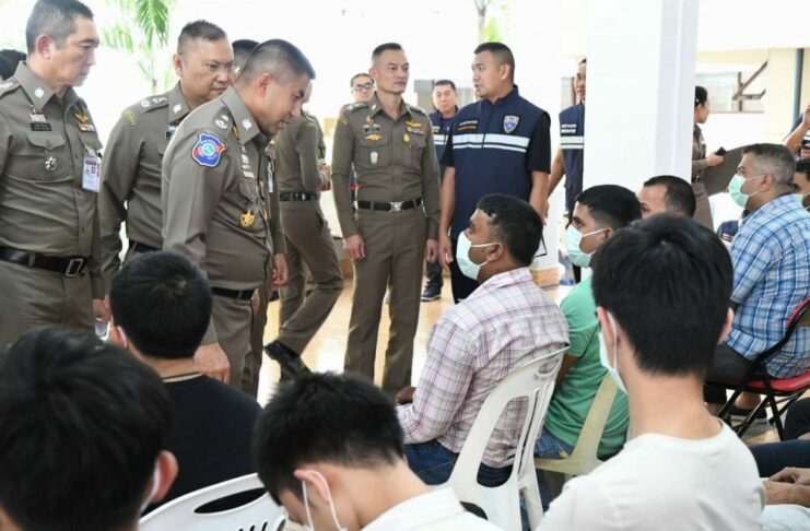 Immigration Chief Vows Crackdown on Illegal Foreign Workers Maj. Gen. Surachet Hakpan, third from left, talks to foreigners arrested for illegally working in Thailand on Thursday at the Immigration Bureau.