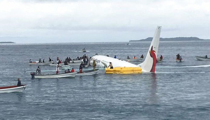Local fishing boats move in to recover the passengers and crew of an Air Niugini flight Friday following the plane crashing into the sea on its approach to Chuuk International Airport in the Federated States of Micronesia. Photo: James Yaingeluo / Associated Press