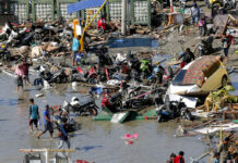 Burials Beginning in Indonesia as Rescue Need Grows Urgent People survey damage outside the shopping mall following earthquakes and a tsunami in October in Palu, Central Sulawesi, Indonesia. Photo: Tatan Syuflana / Associated Press