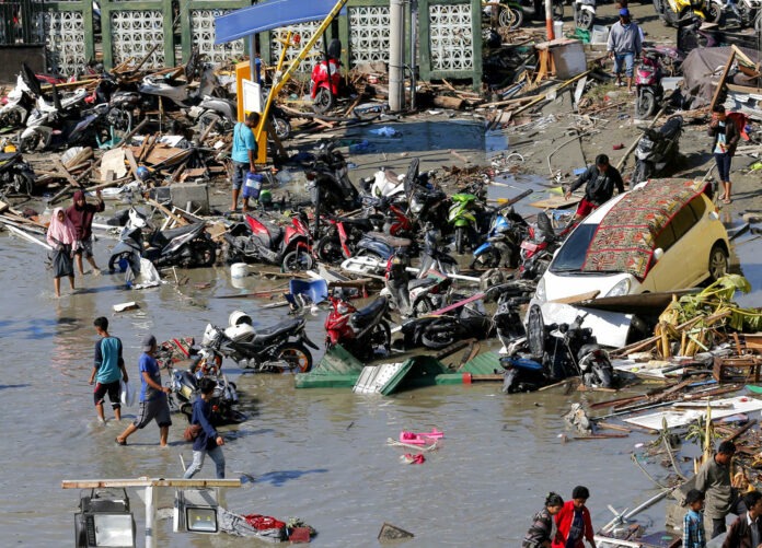 People survey damage outside the shopping mall following earthquakes and a tsunami in October in Palu, Central Sulawesi, Indonesia. Photo: Tatan Syuflana / Associated Press