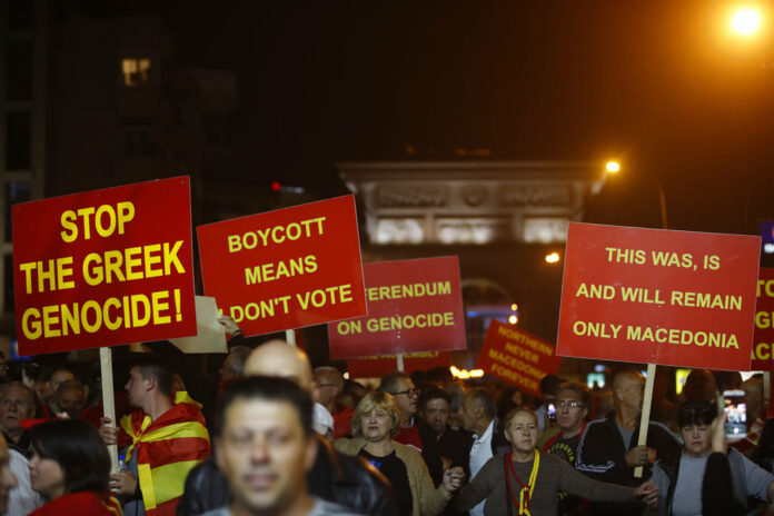 Supporters of a movement for voters to boycott the referendum, hold placards Sunday as they celebrate in central Skopje, Macedonia, after election officials gave low turnout figures. Photo: Thanassis Stavrakis / Associated Press