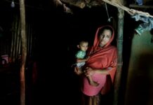 From Squalid Refugee Camp, Rohingya Teen Plans for Higher Ed Rohingya refugee woman Minara Begum, mother of Rahima Akter, holds her youngest daughter Arohi Zannat inside the family hut in August in Kutupalong refugee camp, Bangladesh. Photo: Altaf Qadri / Associated Press